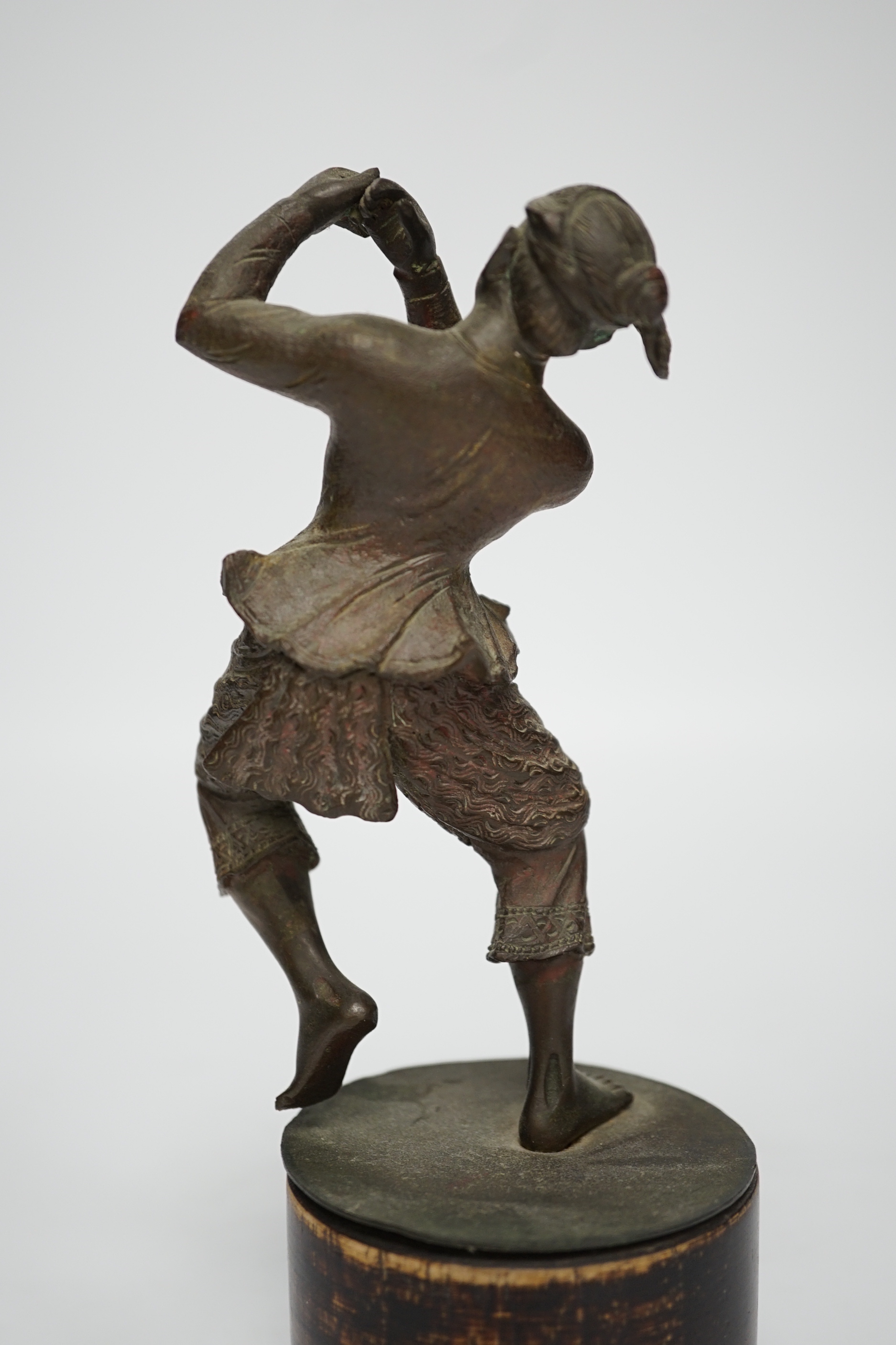 A small bronze figure of a Javanese dancer on a wooden base, 18.5cm